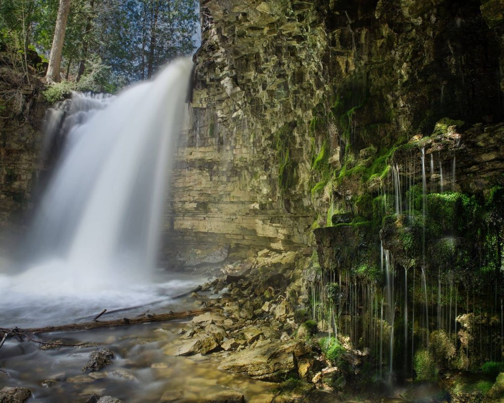 Hilton Falls Conservation Area in Milton, Ontario featuring a picturesque waterfall cascading over rocks.